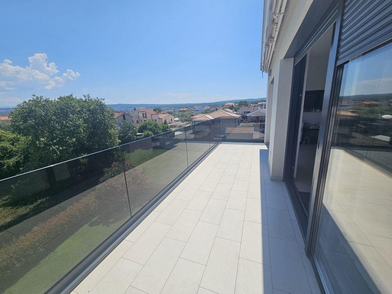 Duży balkon ze szklanymi balustradami i widokiem na morze