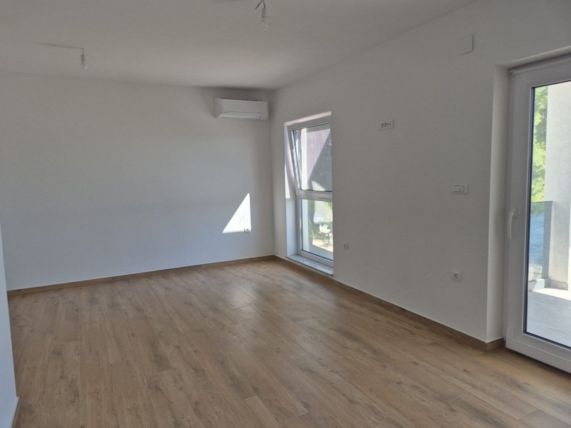 Część dzienna penthouse'u z drewnianymi podłogami i oknami
