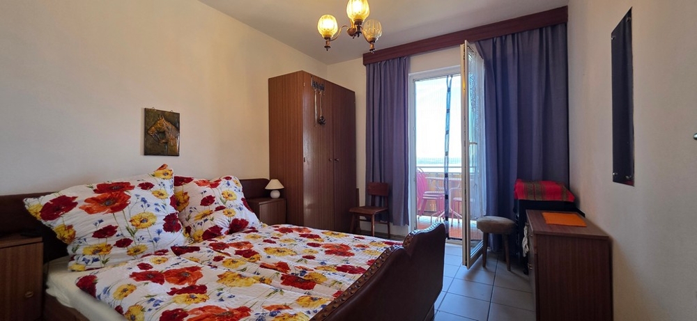 Sypialnia z podwójnym łóżkiem i drzwiami balkonowymi, apartament A4103