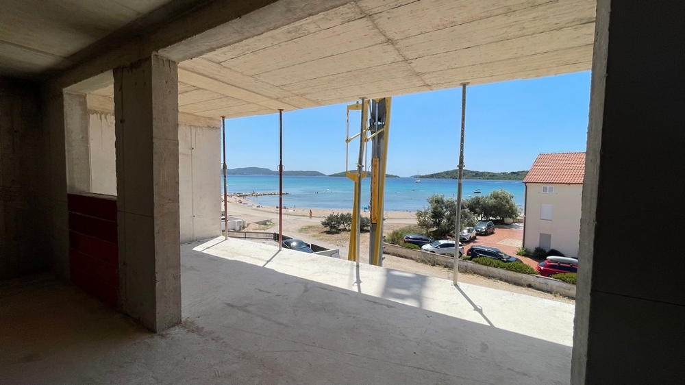 Widok ze stanu surowego apartamentu na plażę i morze