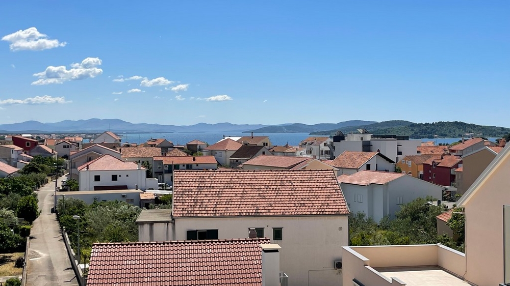 Widok na morze z penthouse'u w Vodicach ponad dachami miasta