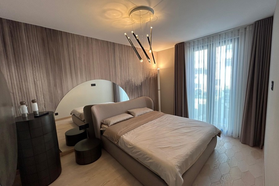 Sypialnia z tapicerowanym łóżkiem i designerskim oświetleniem