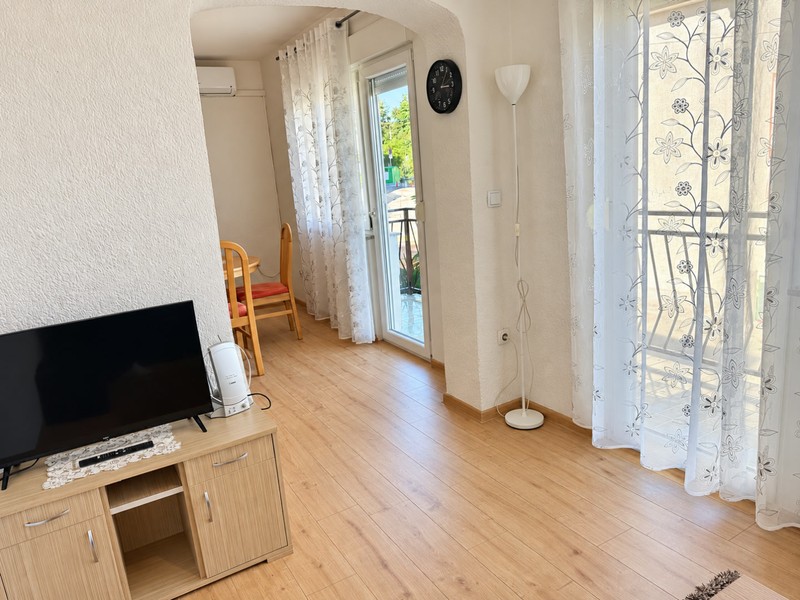 Część dzienna z telewizorem i drzwiami na balkon