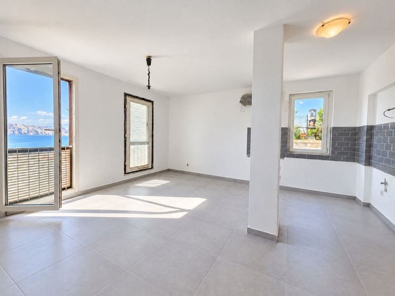 Salon z drzwiami na balkon i widokiem na morze