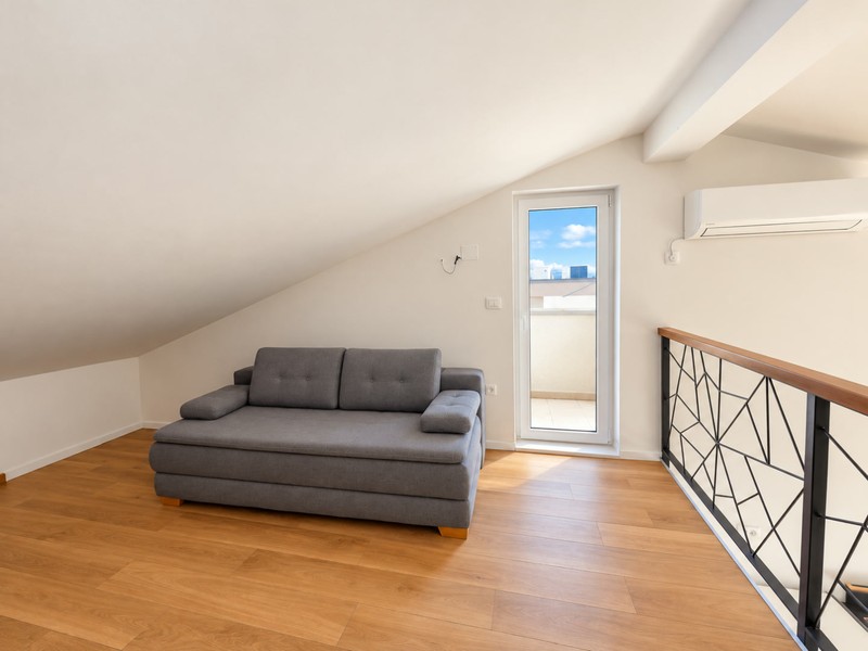 Galeria z sofą rozkładaną i drzwiami na balkon