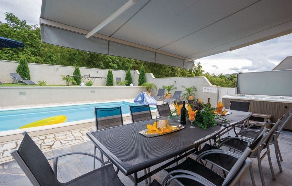 Taras i basen za domem z widokiem na przyległy las.