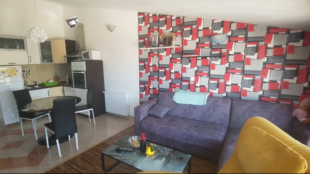 Dalszy salon z częścią wypoczynkową i widokiem na kuchnię