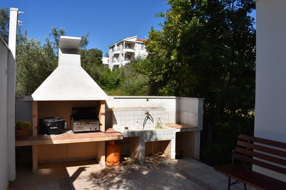 Kolejna sypialnia z otwartymi drzwiami balkonowymi i widokiem na ogród