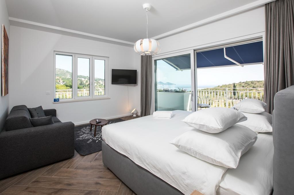 Sypialnia z balkonem i widokiem na zieleń.