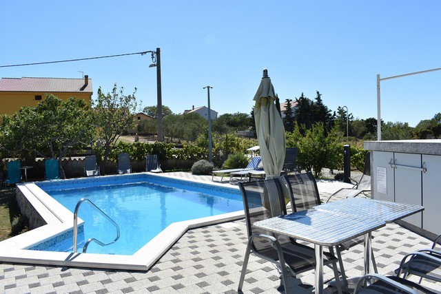 Widok z salonu na basen i ogród w Chorwacji.