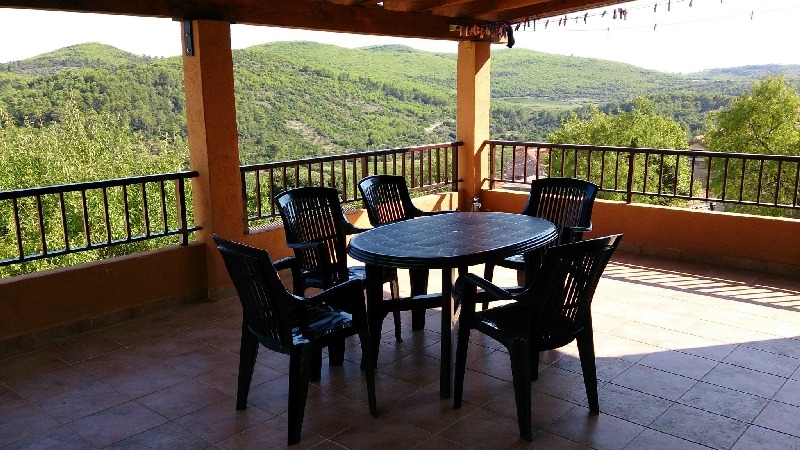 Widok na zadaszony balkon z pięknym widokiem na idylliczną okolicę.