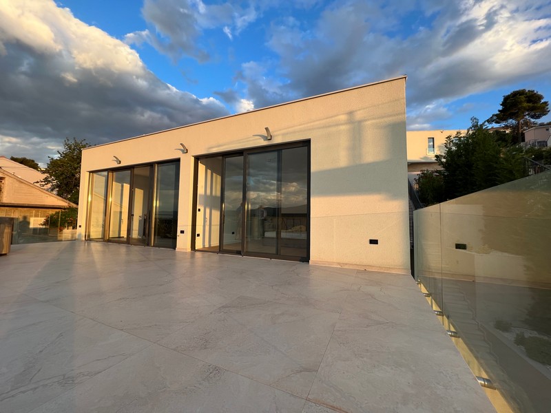 Pokój dzienny z widokiem na basen i morze w nieruchomości H1921, wyspa Ciovo, Chorwacja.