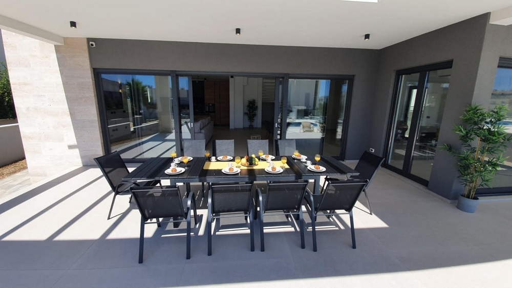 Nowoczesny taras z zadaszoną jadalnią.