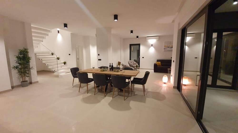 Otwarta przestrzeń ze stołem jadalnym i widokiem na klatkę schodową.