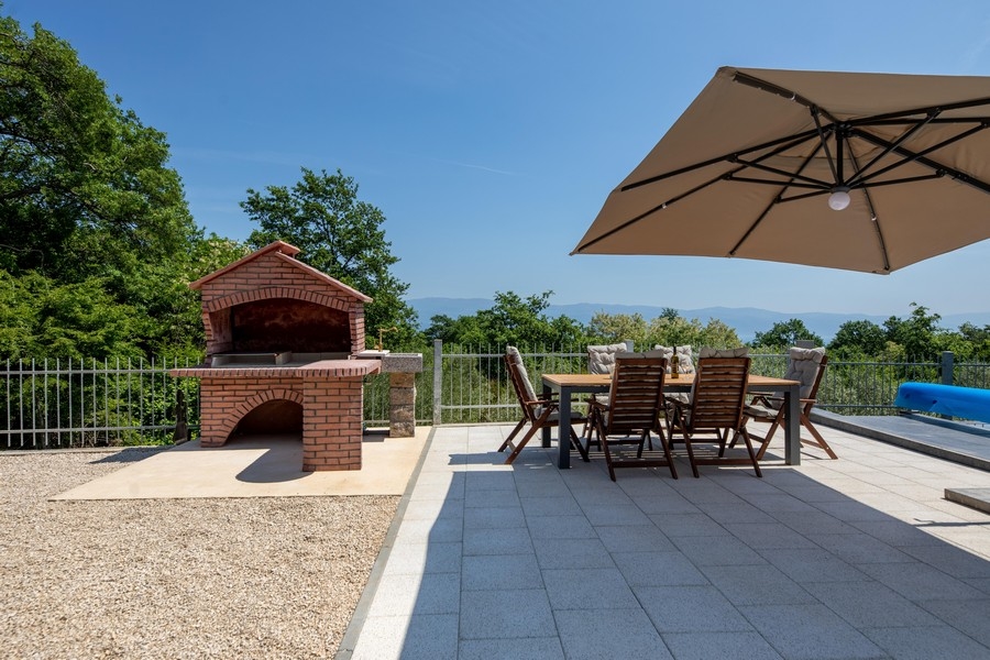 Taras z basenem i grillem.