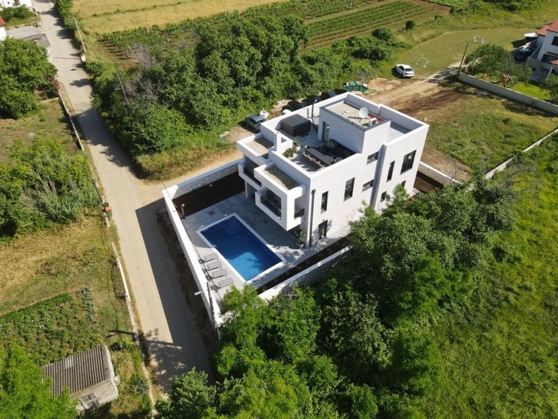 Widok z lotu ptaka na luksusową willę z basenem w zielonej okolicy