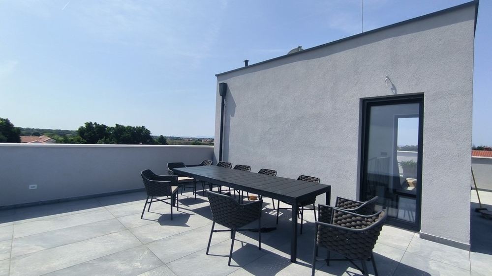 Taras na dachu z dużym stołem jadalnym i widokiem