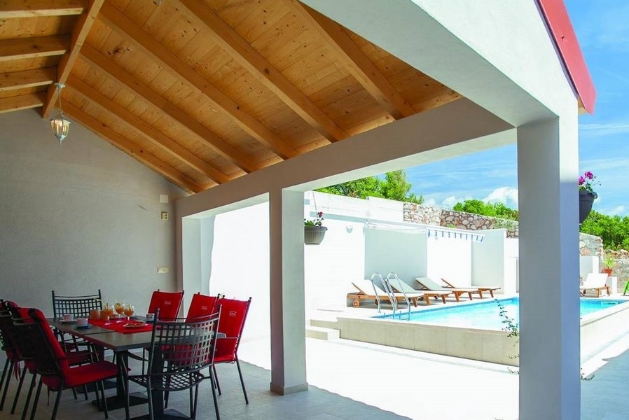 Zadaszona jadalnia i widok na basen.