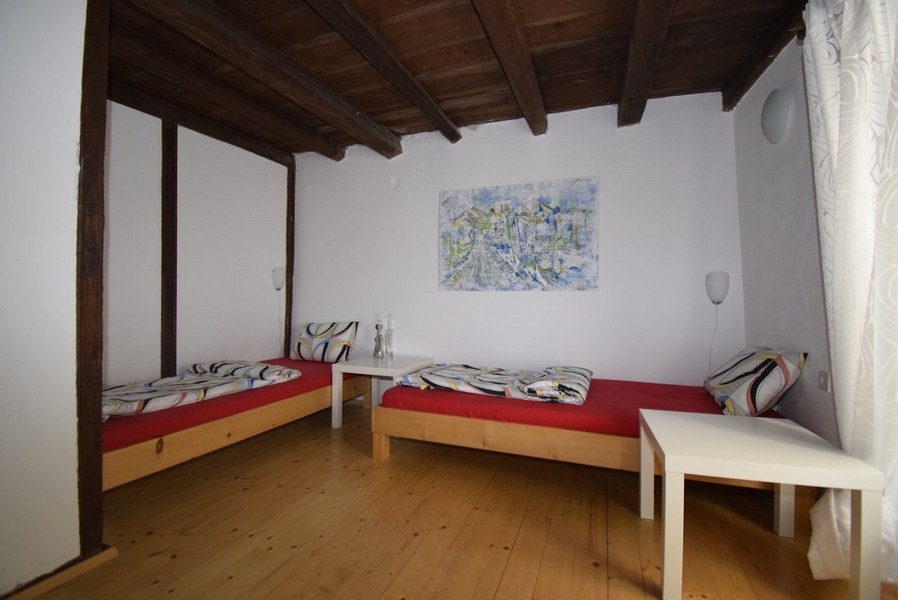 Sypialnia z dwoma pojedynczymi łóżkami (drewnianymi).