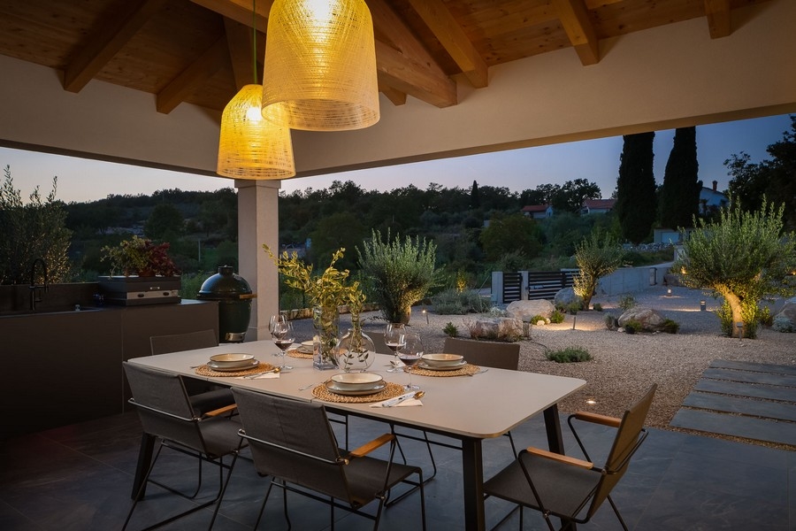 Zadaszony taras ze stołem jadalnym i nastrojowym oświetleniem