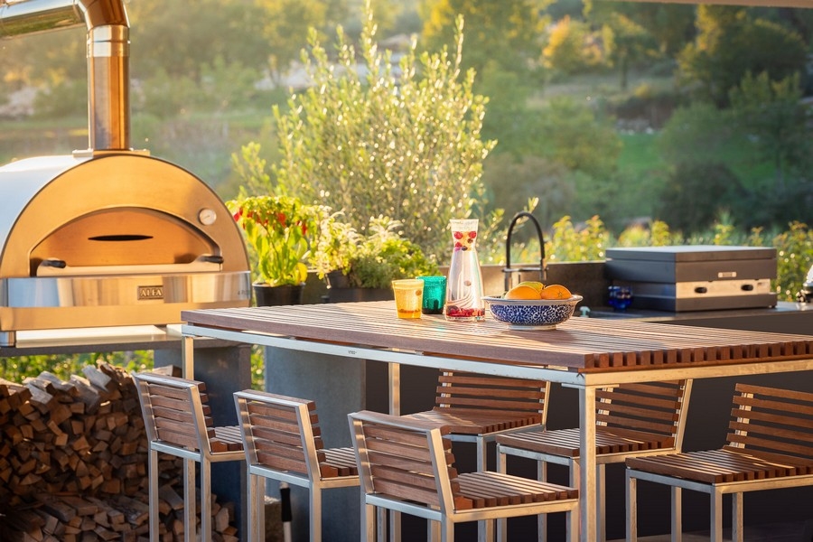 Kuchnia na świeżym powietrzu z piecem do pizzy i miejscami do siedzenia