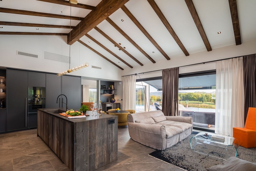 Otwarta część dzienna z kuchnią i odsłoniętymi belkami stropowymi