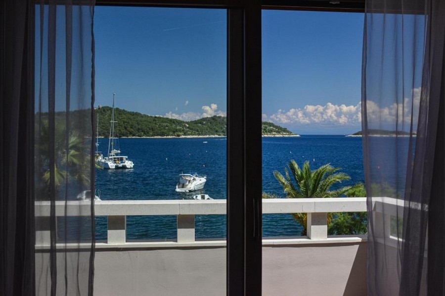 Willa z kamienną fasadą i tarasem z leżakami otoczona śródziemnomorską roślinnością - Nieruchomości Chorwacja H2846