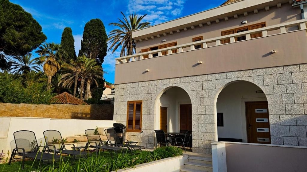 Sypialnia ze ścianą z kamienia naturalnego, dużym oknem i widokiem na zieloną roślinność - Nieruchomość Chorwacja H2846