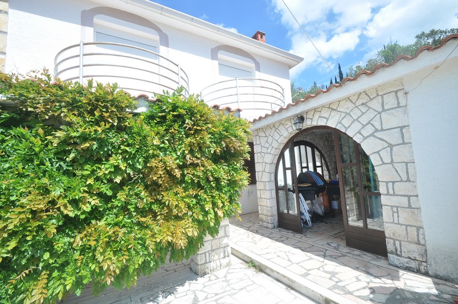 Strefa wejściowa śródziemnomorskiego domu nad morzem w Chorwacji z kamienną architekturą.