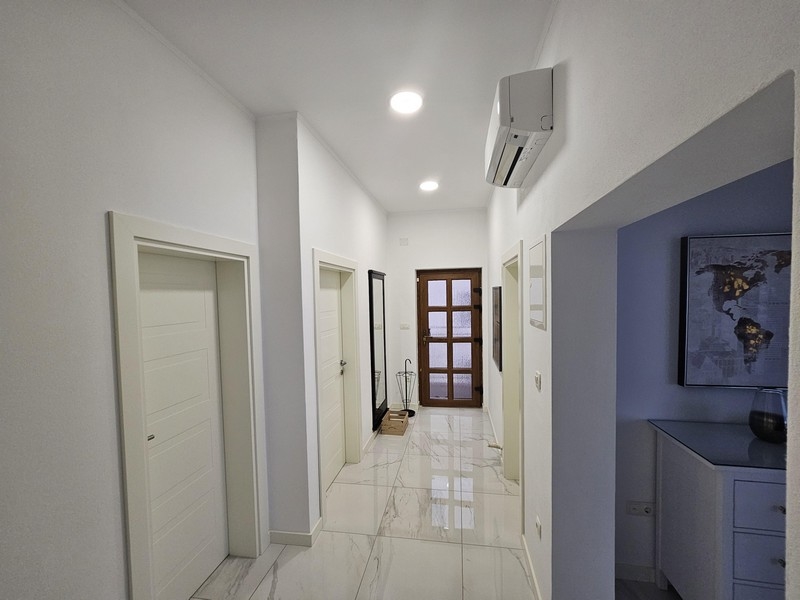 Jasny i przestronny korytarz z błyszczącymi podłogami w nadmorskim apartamentowcu w Chorwacji