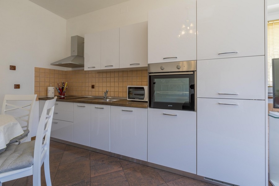 Nowoczesna biała kuchnia z jadalnią w nadmorskiej posiadłości w Chorwacji