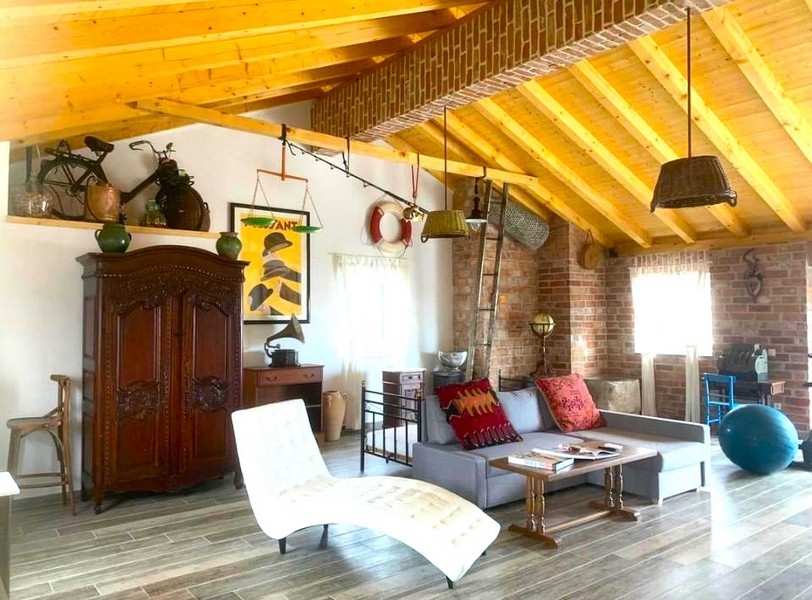 Rustykalny urok spotyka się z nowoczesnym komfortem w salonie tego kamiennego domu na sprzedaż w Chorwacji.