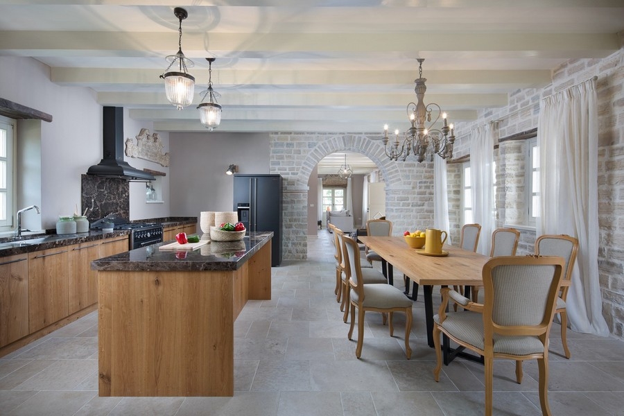 Nowoczesna kuchnia z drewnianą wyspą, żyrandolami i długim stołem jadalnym, gotowa do posiłku - Willa na sprzedaż Chorwacja H2879