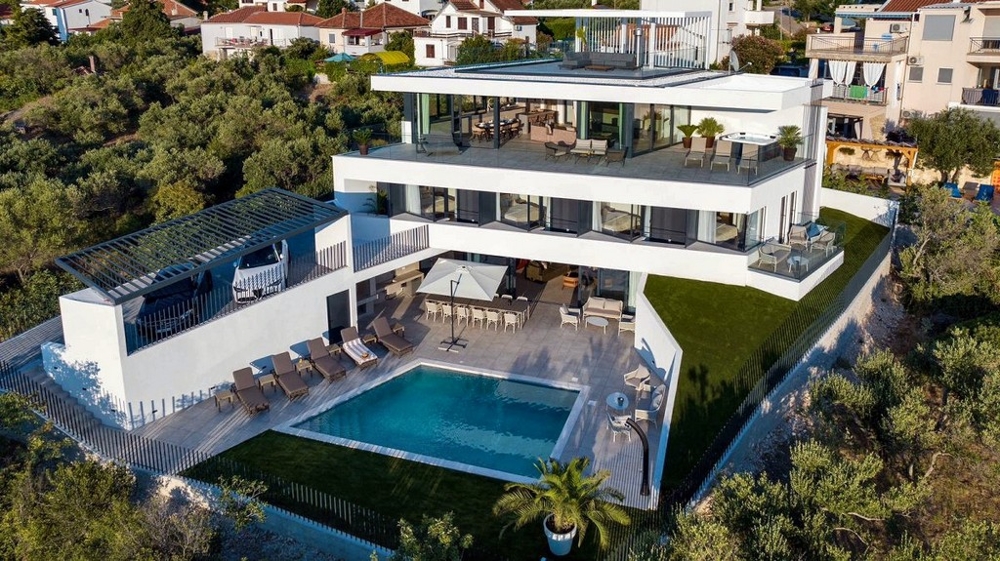 Widok z lotu ptaka na sprzedaż willi w Chorwacji z tarasem na dachu i basenem.