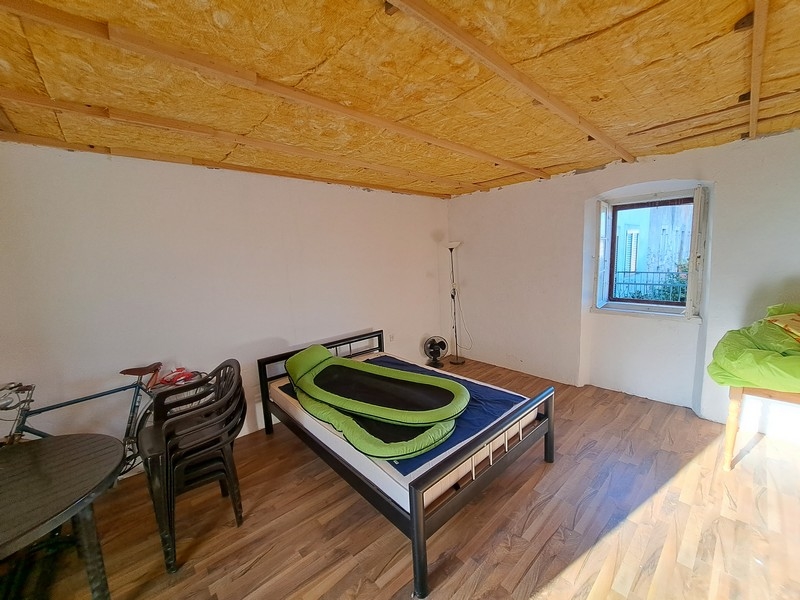 Jasna sypialnia z drewnianym sufitem i minimalistycznym wystrojem w nieruchomości w Chorwacji, dostępna za pośrednictwem Panorama Scouting.