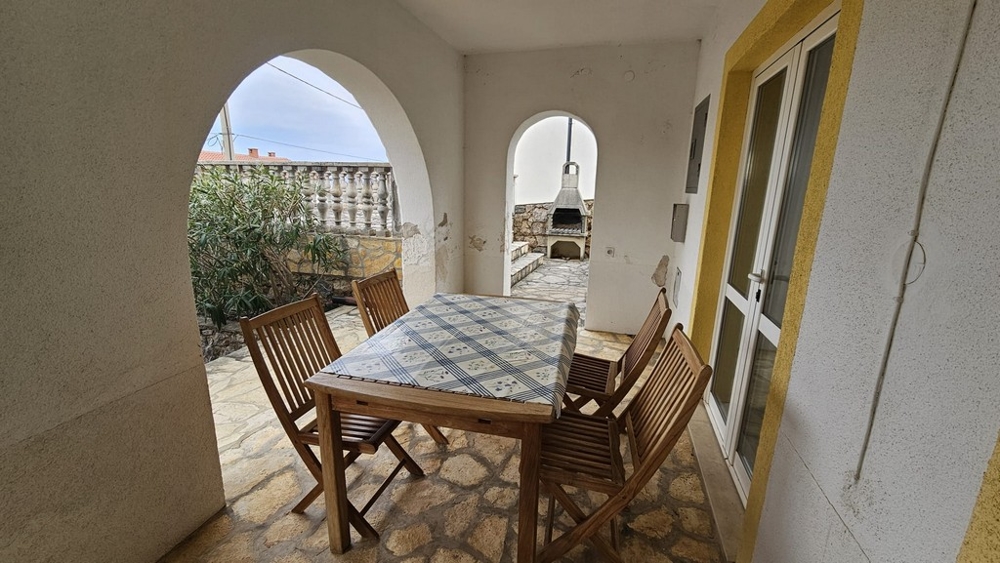 Zadaszony taras zewnętrzny ze stołem jadalnym w domu na sprzedaż w Karlobag