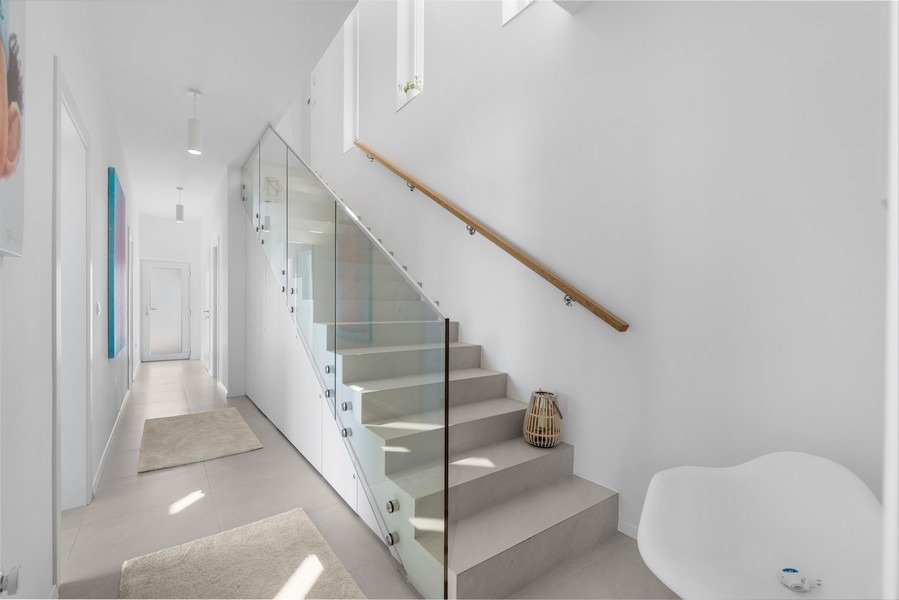 Nowocześnie zaprojektowane schody ze szklanymi balustradami w willi na Istrii, sprzedawane przez Panorama Scouting