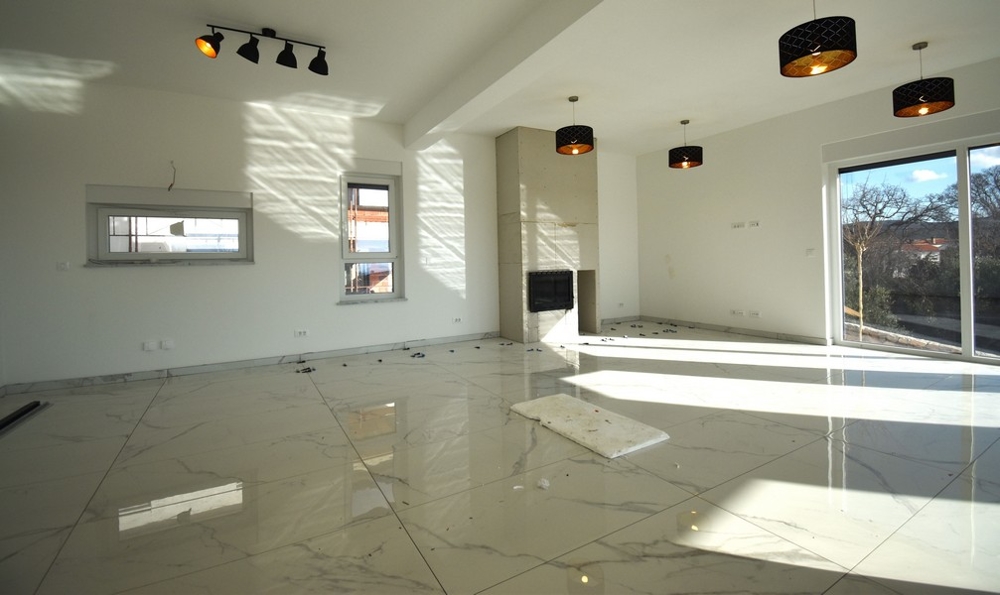 Słoneczny salon z kominkiem i oknem w nowoczesnej willi na wyspie Krk.