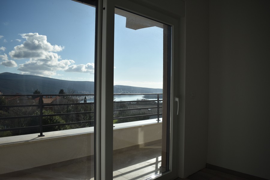 Otwarte drzwi na balkon z widokiem na morze w nowo wybudowanej willi na wyspie Krk.