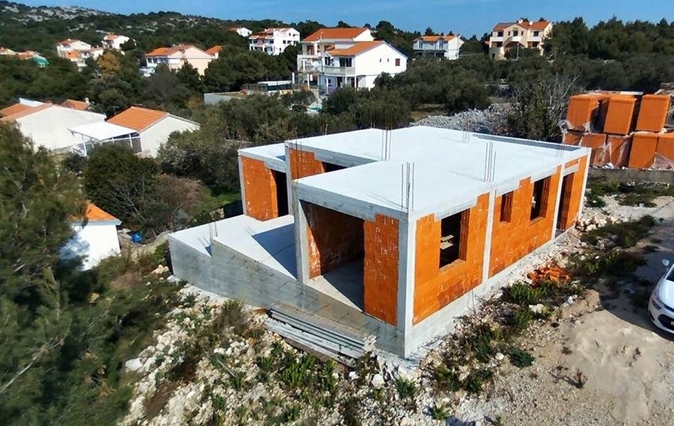 Szczegółowy widok budowy willi z odsłoniętymi ceglanymi ścianami i betonowymi kolumnami na sprzedaż na wyspie Krk w Chorwacji