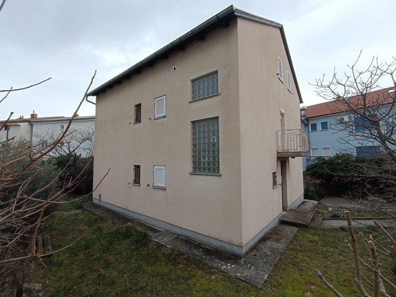 Widok z boku budynku mieszkalnego na sprzedaż w Crikvenicy w Chorwacji, z widocznym ogrodem