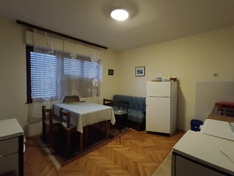 Wnętrze mieszkania ze stołem jadalnym i sprzętem kuchennym w apartamentowcu na sprzedaż w Crikvenicy w Chorwacji