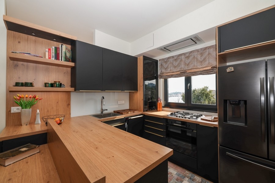 Widok wnętrza nowoczesnej kuchni w willi na sprzedaż na Ugljan, z drewnianymi akcentami i widokiem na morze.