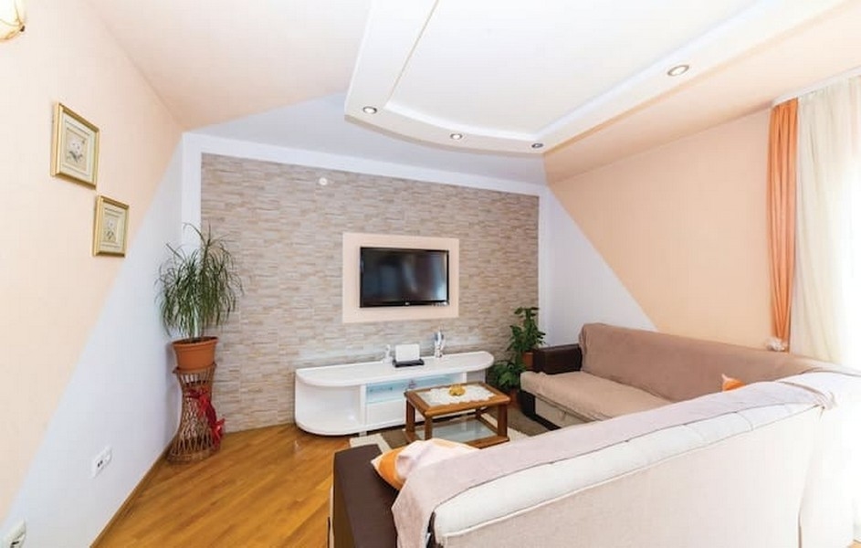 Pokój dzienny z sofą i telewizorem w apartamentowcu na sprzedaż w Kaštel Lukšić, Chorwacja