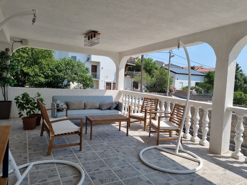 Zadaszony taras zewnętrzny z miejscem do siedzenia w apartamentowcu na sprzedaż w Karlobag w Chorwacji.