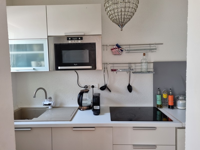 Nowoczesna kuchnia we wnętrzu apartamentowca w Karlobag w Chorwacji, z urządzeniami kuchennymi i powierzchniami roboczymi.