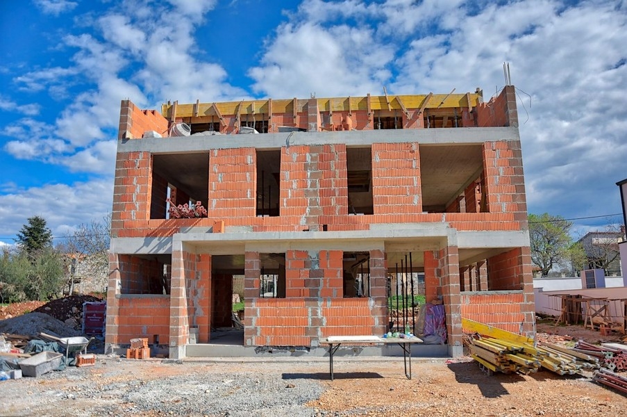 Stan surowy domu bliźniaczego, perspektywa boczna, w trakcie budowy