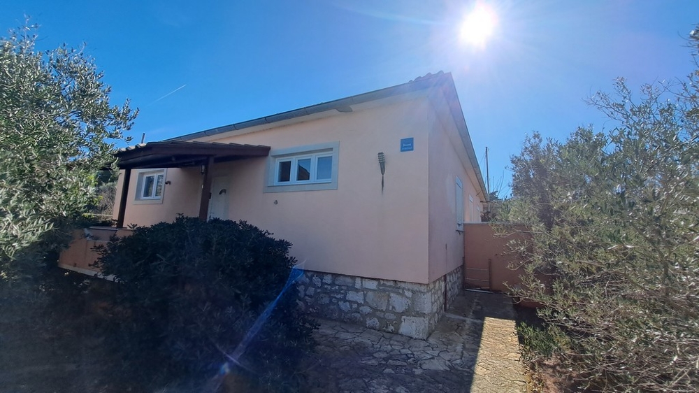 Widok z boku domu otoczonego roślinnością śródziemnomorską, posiadłość nadmorska w Chorwacji