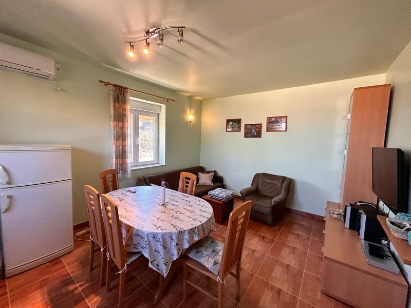 Pokój dzienny ze stołem jadalnym i wyposażeniem kuchni, wewnątrz części nadmorskiej posesji w Chorwacji