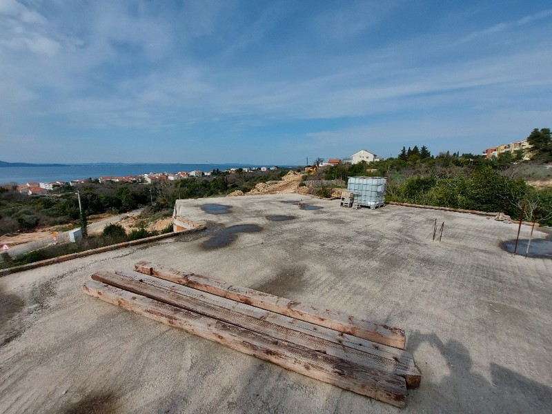 Plac budowy z betonowym fundamentem i drewnianymi belkami pod prawie ukończony dom jednorodzinny w Diklo w Chorwacji